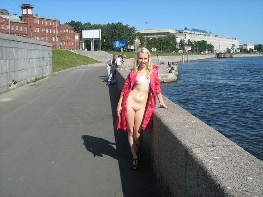 Худая блондинка позирует голышом в публичном месте на набережной